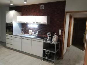 里沃Willa na klifie的厨房配有白色橱柜和砖墙