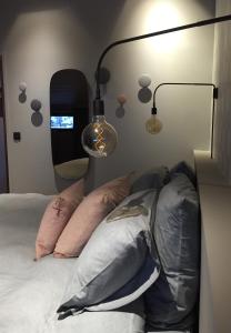 夏蒙尼-勃朗峰Le petit M Chamonix au pied du Brévent的一间卧室配有两盏灯和一张带枕头的床。
