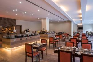 多哈多哈协和大酒店的一间带桌椅的餐厅和一间酒吧