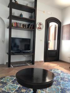 阿西亚罗利Residenza Le Serre的客厅配有黑咖啡桌和电视