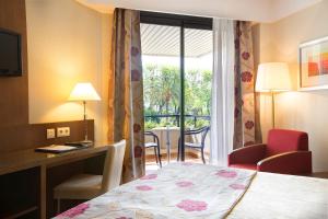 赫雷斯-德拉弗龙特拉雪莉公园时尚酒店的配有一张床、一张书桌和一扇窗户的酒店客房