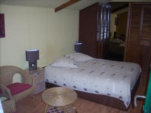 布赖恩拉勒莱斯贝格斯床和早餐旅馆的一间卧室配有一张大床和一把椅子