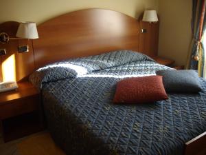 阿尔玛·迪·塔吉亚Ristorante Albergo Roma的一间卧室配有一张带木制床头板的床