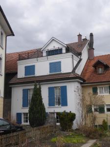 拉格斯Haus Gaschür的白色的房子,上面有蓝色百叶窗