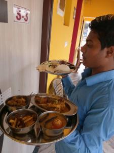 博尔普尔Asian Grand Villa的一个人拿着一盘食物