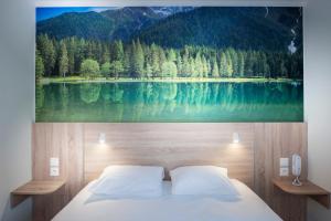 安纳马斯Kyriad Annemasse - Geneve的卧室配有一幅湖面大画