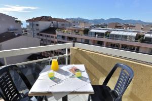 戛纳渣油戛纳法斯迪瓦勒酒店的阳台顶部一张桌子,上面有2杯饮料