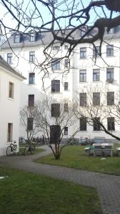莱比锡Bastians Herberge的一座白色的大建筑,前面有自行车停放
