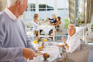Bosau施特劳尔斯湖滨酒店的坐在餐厅桌子上的年纪较大的男女