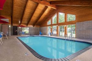 Lake City湖城阿美瑞辛山林小屋和套房酒店的一座大型游泳池,位于一座拥有木制天花板的建筑中