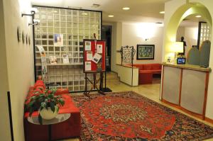 特雷维索艾克佛尔酒店的一间商店大堂,配有红色的沙发和地毯
