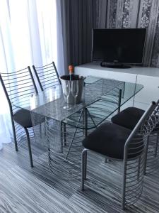 米兹多洛杰Apartament Villa Marea的客厅里设有玻璃桌和椅子
