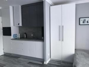 米兹多洛杰Apartament Villa Marea的白色的厨房配有白色橱柜和水槽