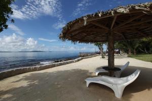 维拉港岛屿魔法公寓度假酒店的海滩上一把遮阳伞下的椅子