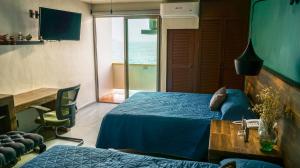 曼萨尼约Hotel Caracoles的一间卧室配有一张床、一张书桌和一个窗户。