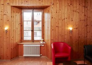 Saint-Saphorin多梅因布里浓酒店的一间设有红色椅子和窗户的房间