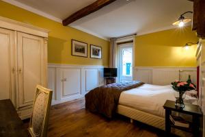黑耶拉特奥博志得司莫克拉酒店的一间卧室设有黄色的墙壁和一张带桌子的床