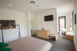坎波巴索拉泰沃纳塔酒店的卧室配有一张床,墙上配有电视。