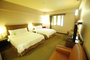 台东康桥商旅-台东馆的酒店客房,设有两张床和一张沙发