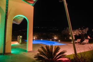 加尔达湖滨Villa Luxury House & Spa的一座晚上设有游泳池的建筑