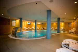 斯库台科罗塞奥Spa酒店的酒店的大型游泳池配有桌椅