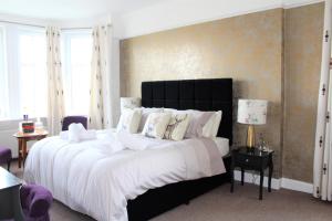 卡罗代尔The Carradale Hotel的卧室配有一张带白色床单和枕头的大床。