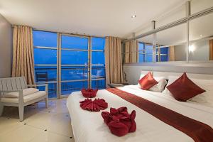波普托享受海滩酒店的酒店的客房 - 带两张带红色枕头的床