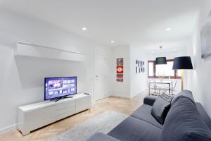 马德里Villanueva Apartments by Flatsweethome的客厅配有蓝色的沙发和电视