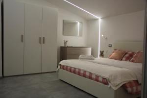 SantʼOmeroAnthos Casa Vacanze的一间白色卧室,配有床和橱柜