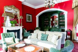 都柏林巴特勒联排别墅酒店的客厅设有红色的墙壁和白色的沙发