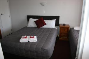 旺阿雷勃艮第玫瑰汽车旅馆的一间卧室配有一张床,上面有两条毛巾