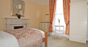 都柏林Donnybrook Townhouse的卧室配有床、壁炉和窗户。