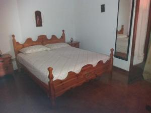 罗切拉伊奥尼卡Appartamenti Bernardo I的卧室内的一张木床,配有镜子