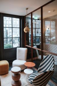 阿姆斯特丹时代大酒店的一间设有两把椅子和一张桌子的房间,窗户