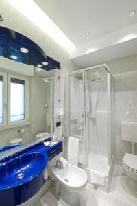维罗纳Mastino Rooms的浴室配有蓝色水槽和淋浴。