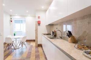 里斯本克鲁兹公寓的厨房配有桌子和白色台面
