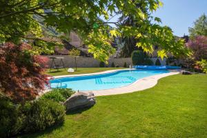 波斯特尔伽尼岗特酒店的一座拥有草地和树木的庭院内的游泳池