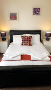 诺丁汉星辰旅馆的一张带白色床单和枕头的床以及两盏灯
