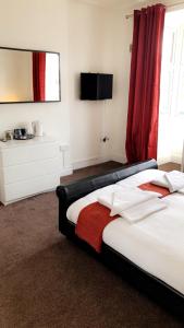 诺丁汉星辰旅馆的一间卧室配有一张带红色窗帘的床