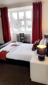 诺丁汉星辰旅馆的一间卧室配有一张带红色窗帘的大床
