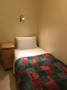 伦敦Seven Dials Hotel的一间小卧室,配有床和床头柜