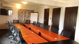 阿布贾Villa Nuee Hotel & Suites Utako, Abuja的一间会议室,配有长桌子和椅子