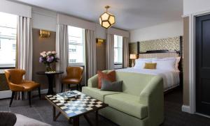 伦敦The Academy - Small Luxury Hotels of the World的酒店客房配有床、沙发和椅子
