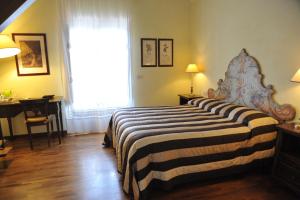 马丁纳弗兰卡瑞莱斯卡萨贝拉酒店的一间卧室配有一张床、一张书桌和一个窗户。