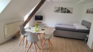 摩泽尔河畔的泽尔摩泽尔美景公寓的小房间设有一张床、一张桌子和椅子