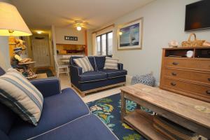 斩魔山Admirals View III by KEES Vacations的客厅配有蓝色的沙发和桌子