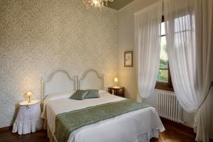 特拉诺瓦-布拉乔利尼Villa Le Facezie B&B的卧室设有一张白色大床和一扇窗户。
