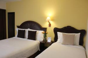 莱昂恩特雷庭院精品酒店的酒店客房,配有两张带白色床单的床