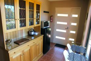 罗斯福尔斯Ou+look BnB的厨房配有木制橱柜和黑色冰箱。