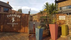 布隆方丹Tsessebe Guesthouse的一座建筑前的木门,有植物